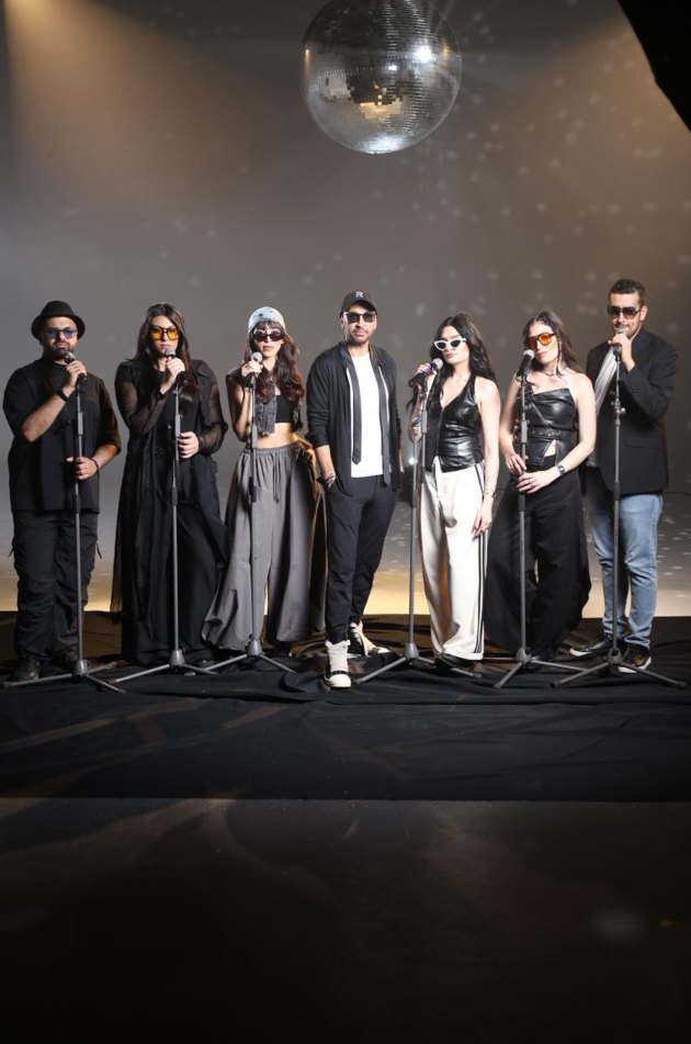 The DNA by Rodge line-up on stage in black under a mirror ball