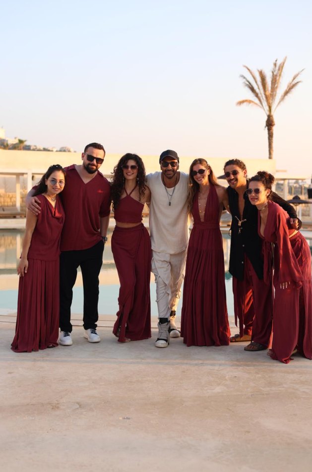 The We Love The Sun collective in burgundy at a poolside sunset
